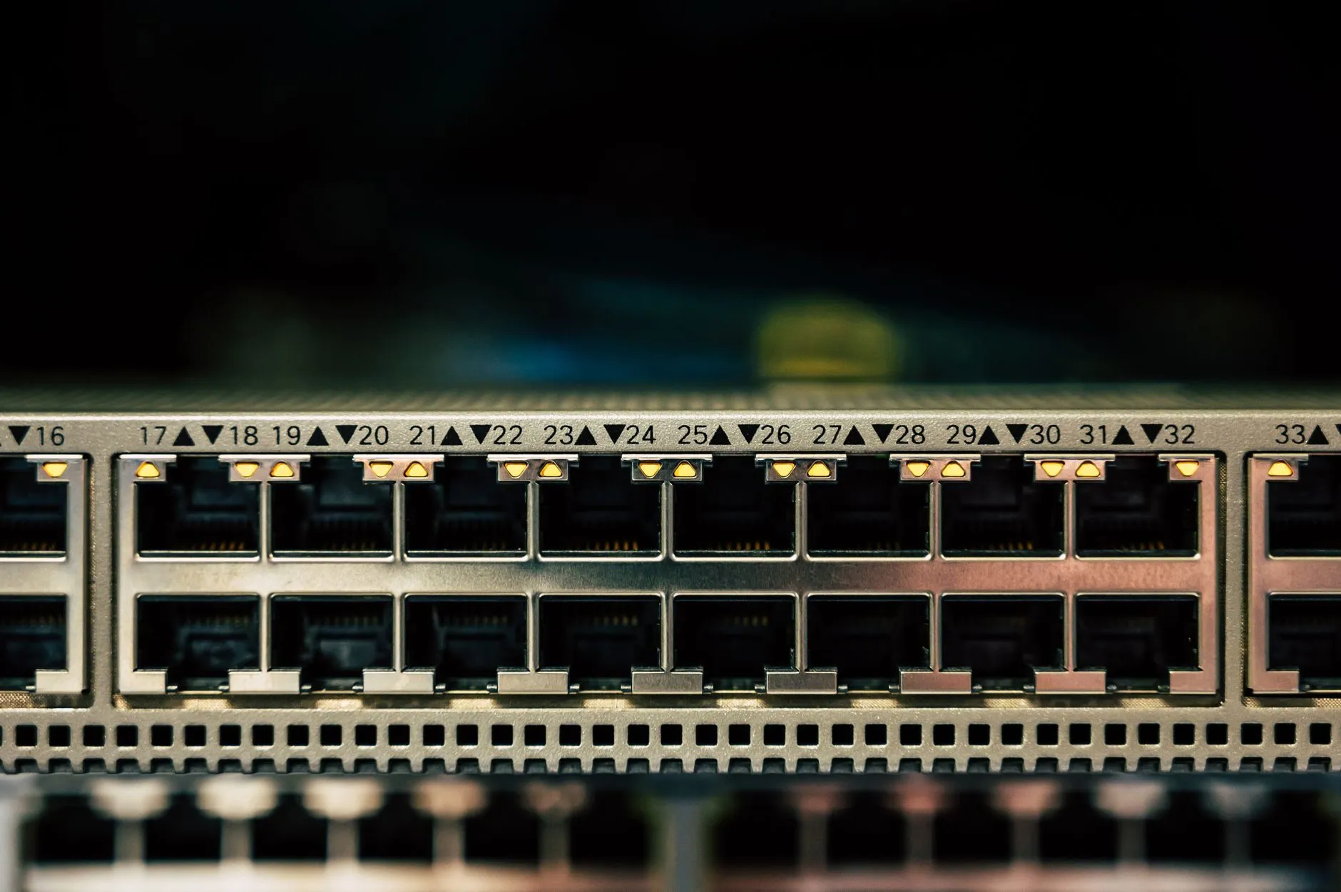 A row of network switch ports with small amber status lights, numbered 17 to 32